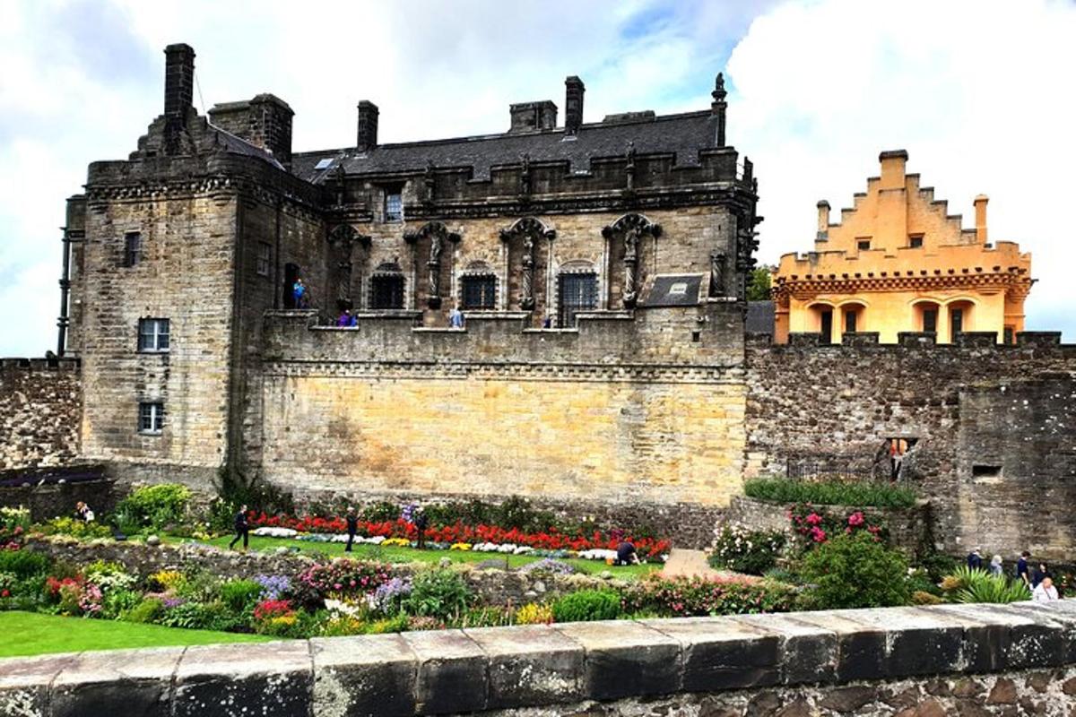 Un antiguo castillo con un jardín delante.