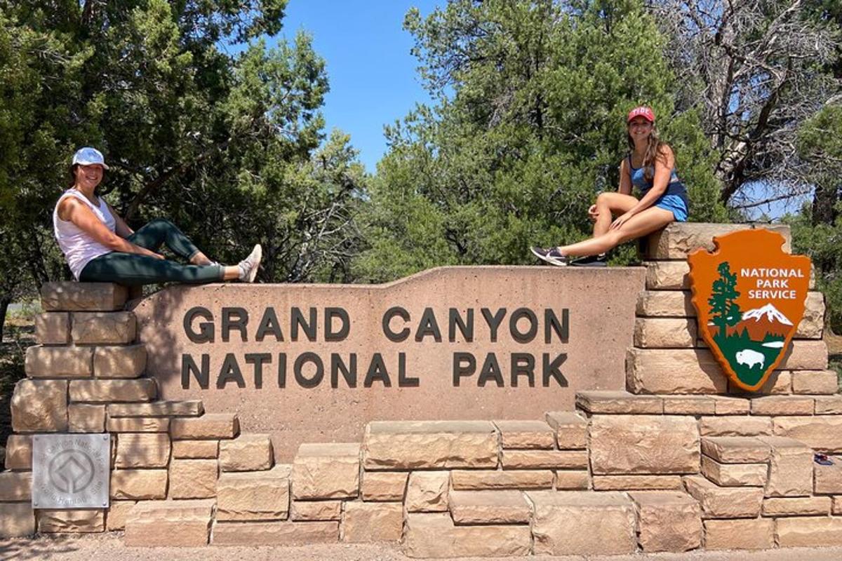 Kaks inimest istuvad sildil Grand Canyoni rahvuspargis
