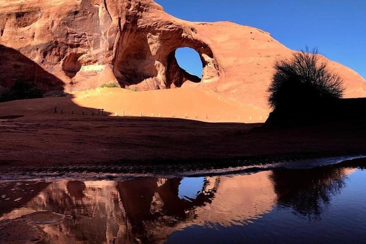 an arch in the desert with its reflection in the water