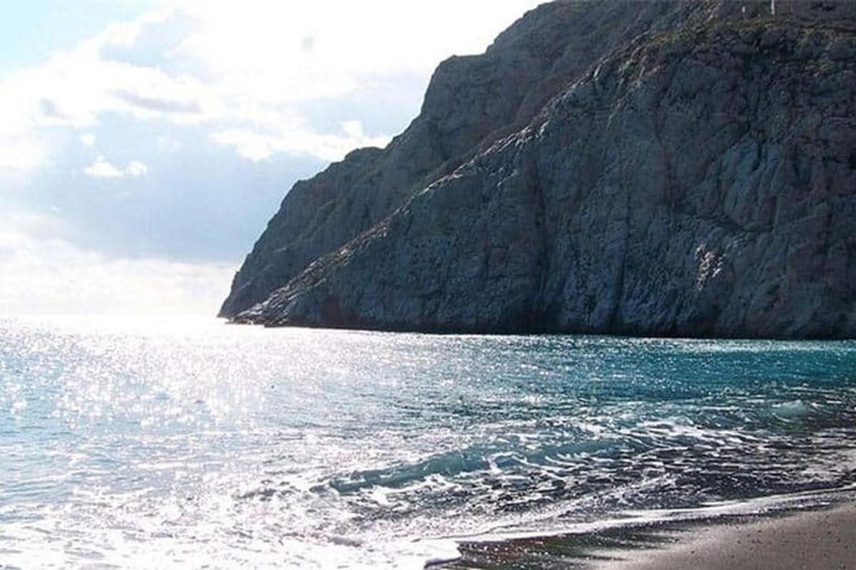 pláž se skalnatou horou a oceánem