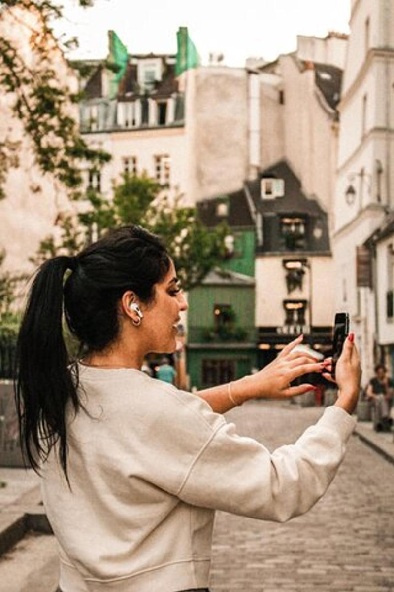 žena fotící se mobilním telefonem