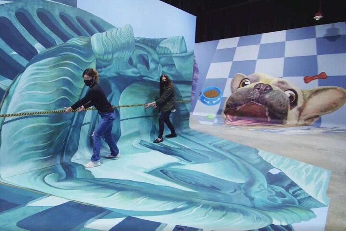 two people painting a mural of a dog
