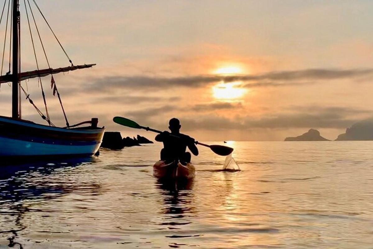 ένας άντρας σε ένα κανό στο νερό με ένα κουπί