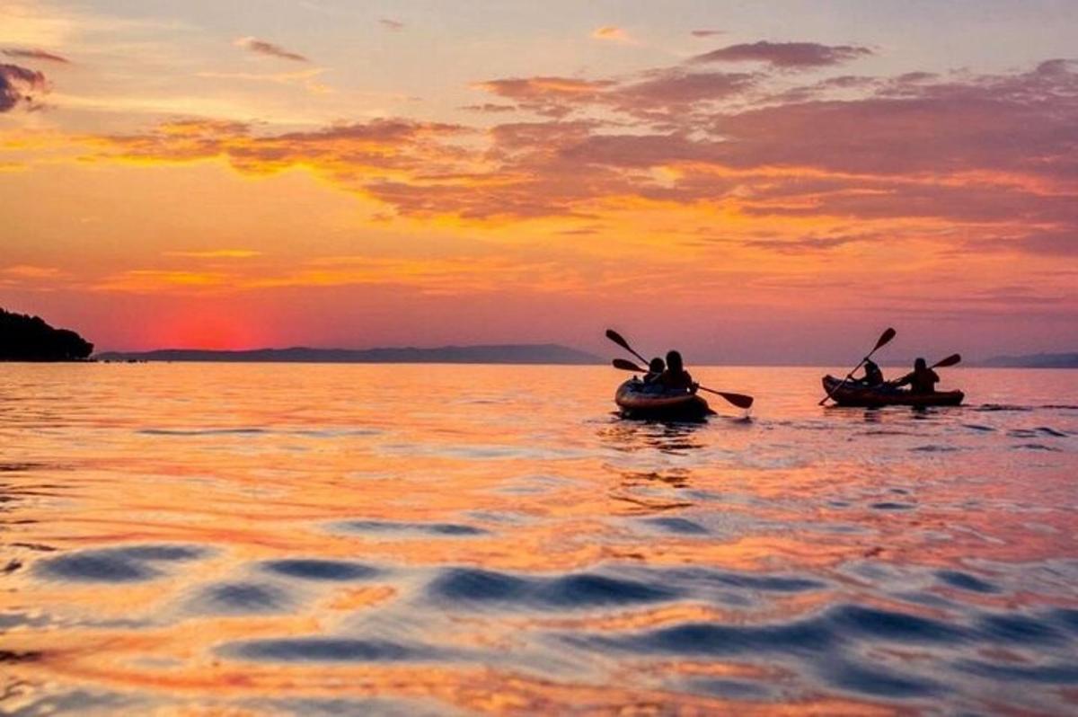 Δύο άτομα σε βάρκες στο νερό στο ηλιοβασίλεμα