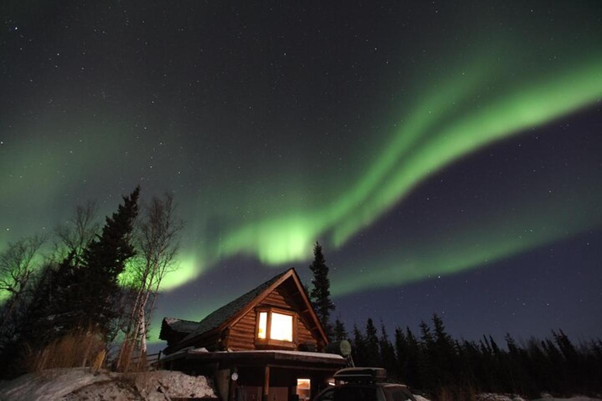 aurora di atas kabin dalam salji pada waktu malam