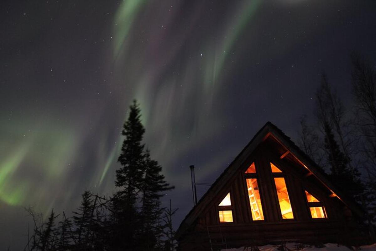 una cabina con una finestra e l'aurora nel cielo