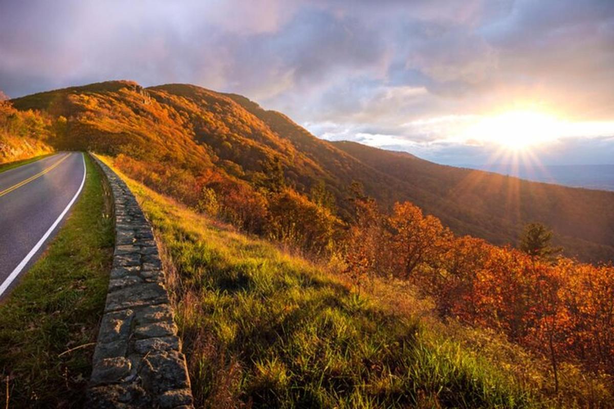 a road in the mountains with the sun setting