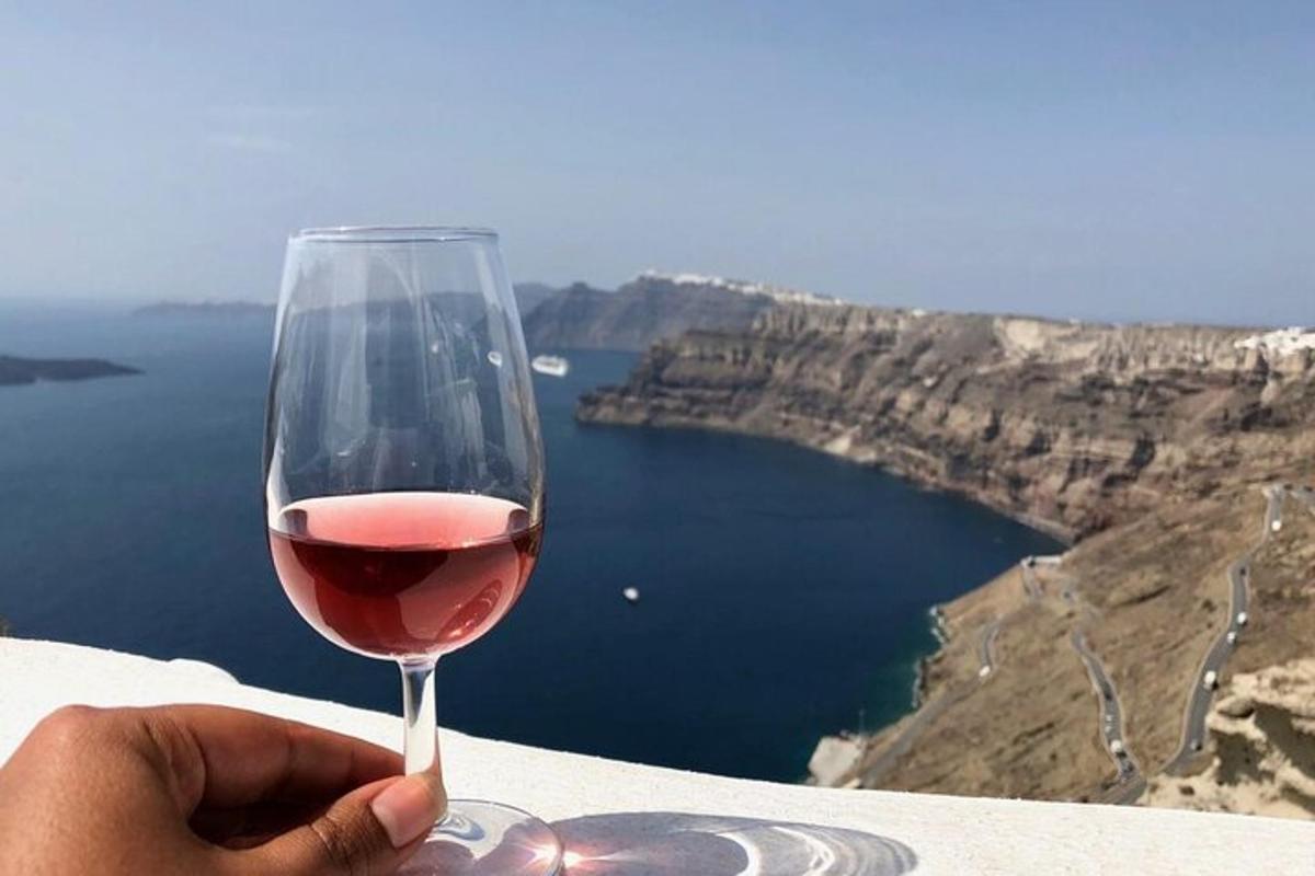 oseba, ki drži kozarec rdečega vina