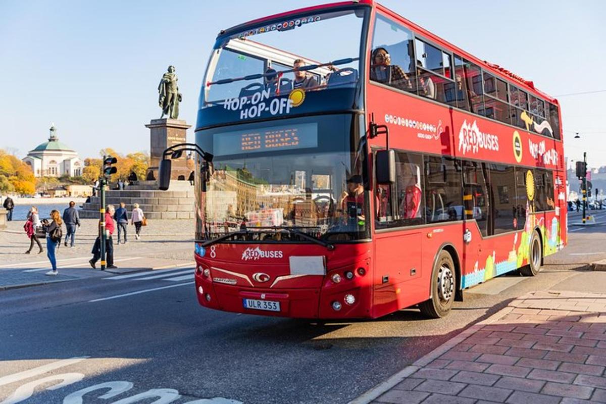 a red double decker bus driving down a street
