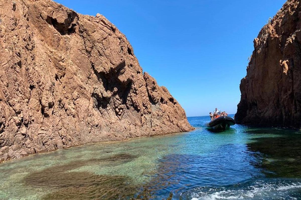 μια βάρκα στο νερό δίπλα σε έναν βραχώδη γκρεμό