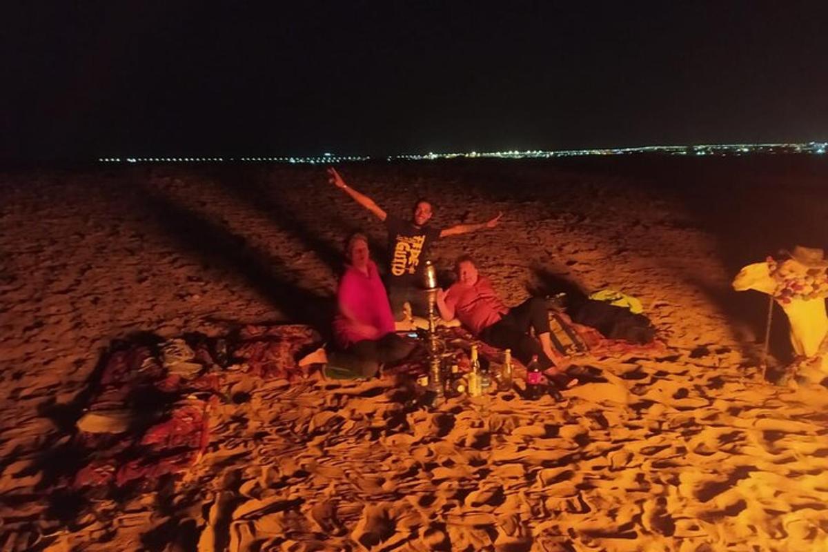 eine Gruppe von Menschen sitzt nachts am Strand