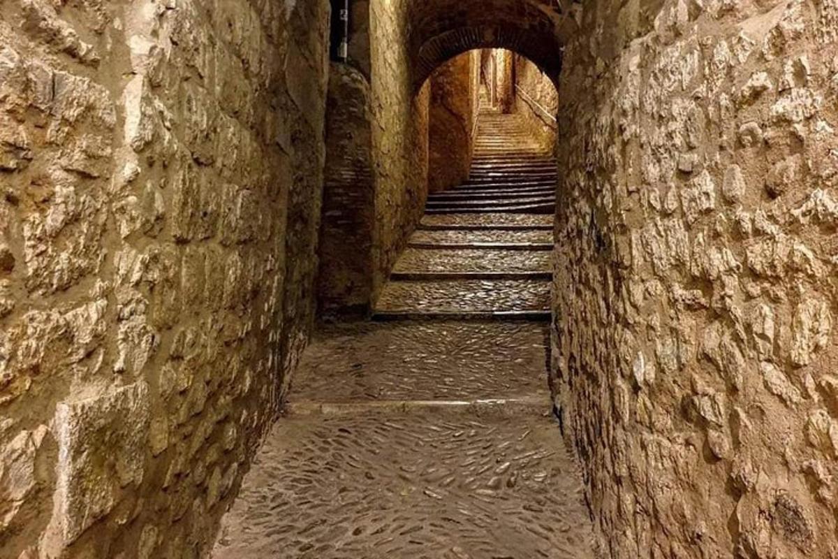 an alley with stone walls and stairs in an alley way