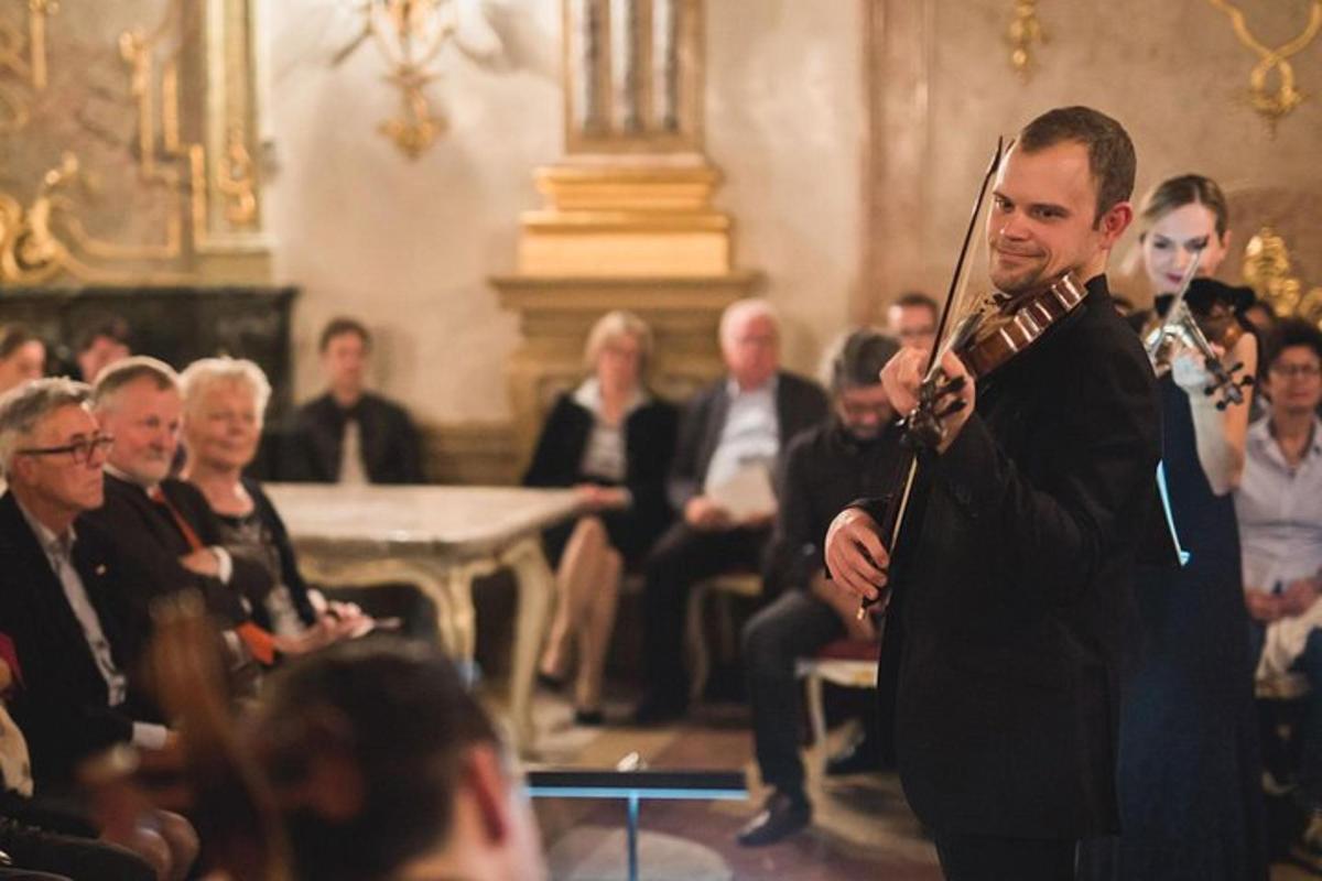 muž hrající na hudební nástroj v davu lidí