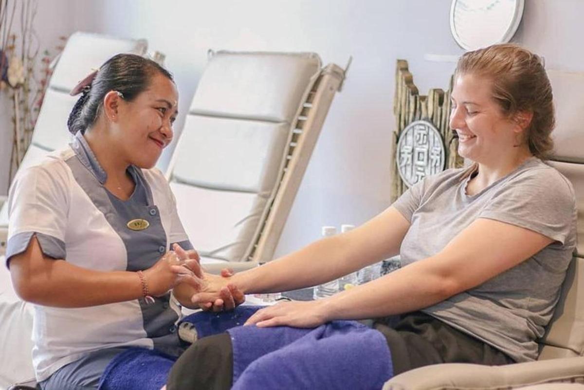 two women sitting in a hospital room holding hands