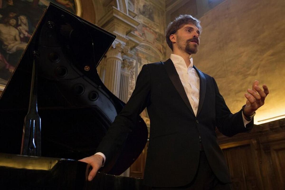 a man in a suit standing next to a piano