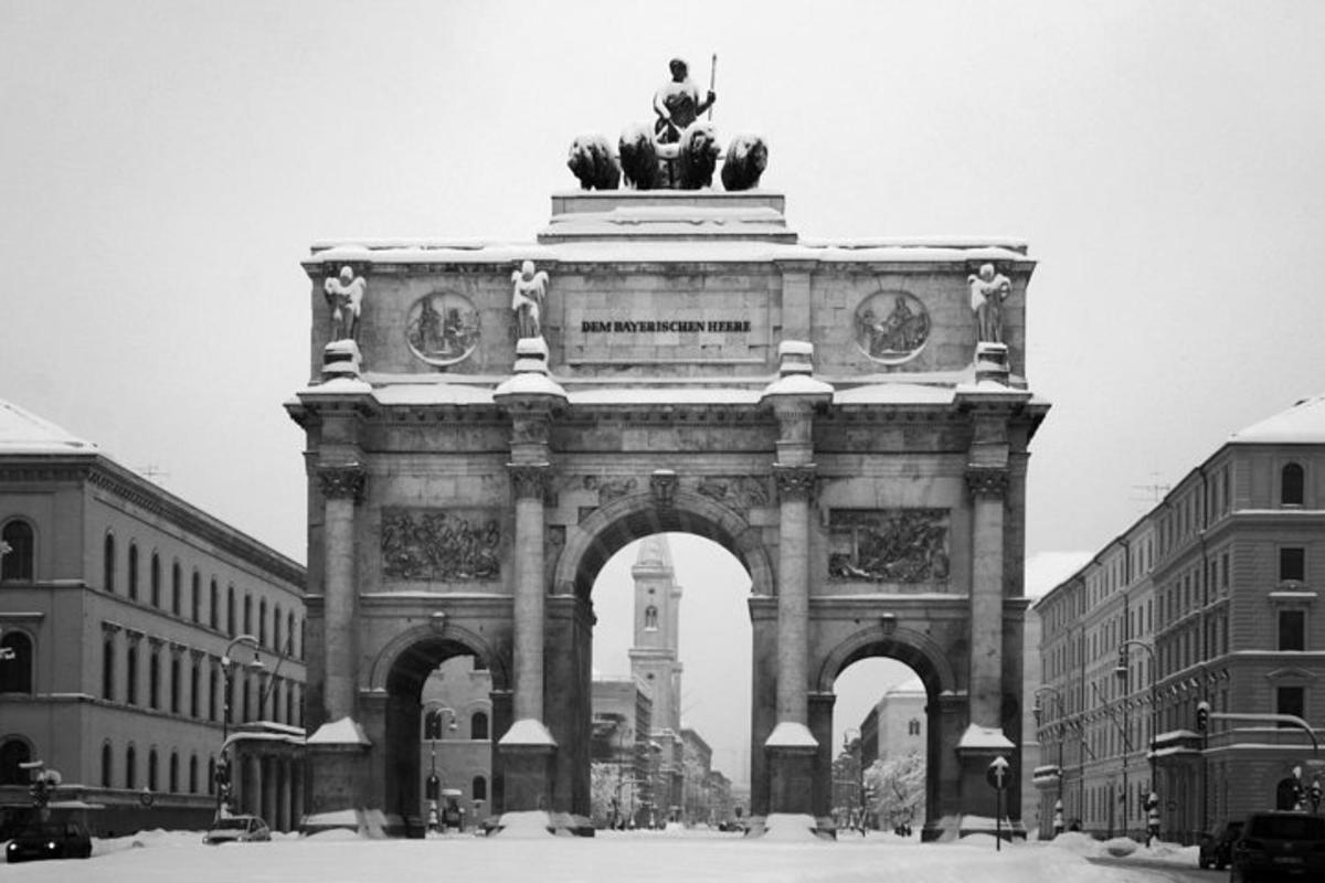 a large building with an arch with a statue
