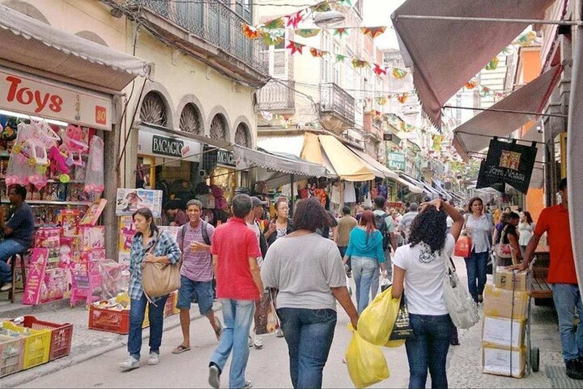 a group of people walking down a street in a market