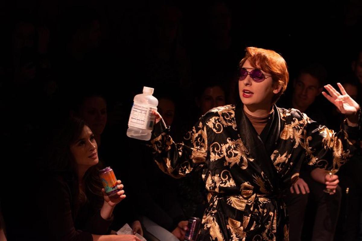 a woman holding a water bottle in front of a crowd