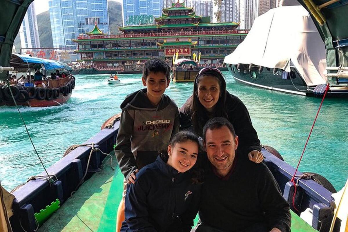 una famiglia in posa per una foto su una barca in acqua