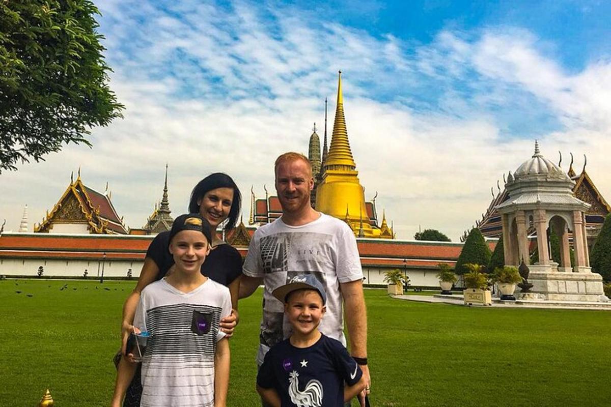 uma família posando para uma foto em frente a um templo