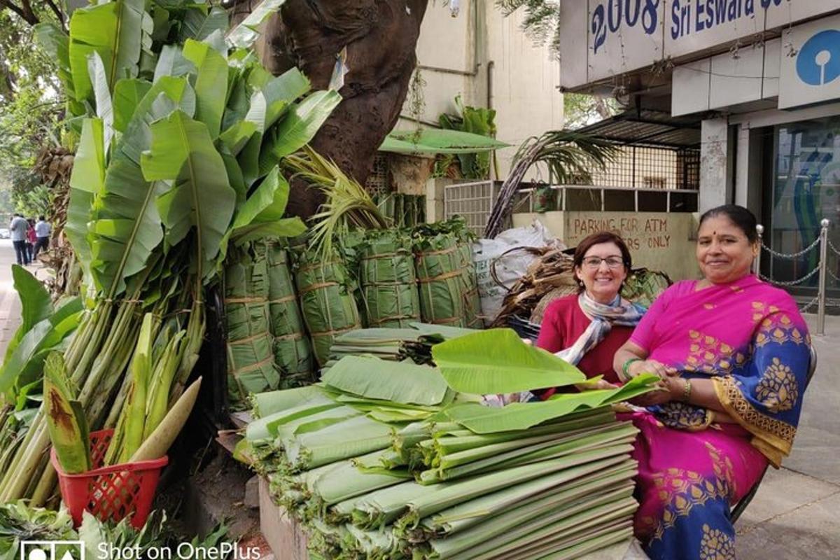 two women sitting next to a display of green plants