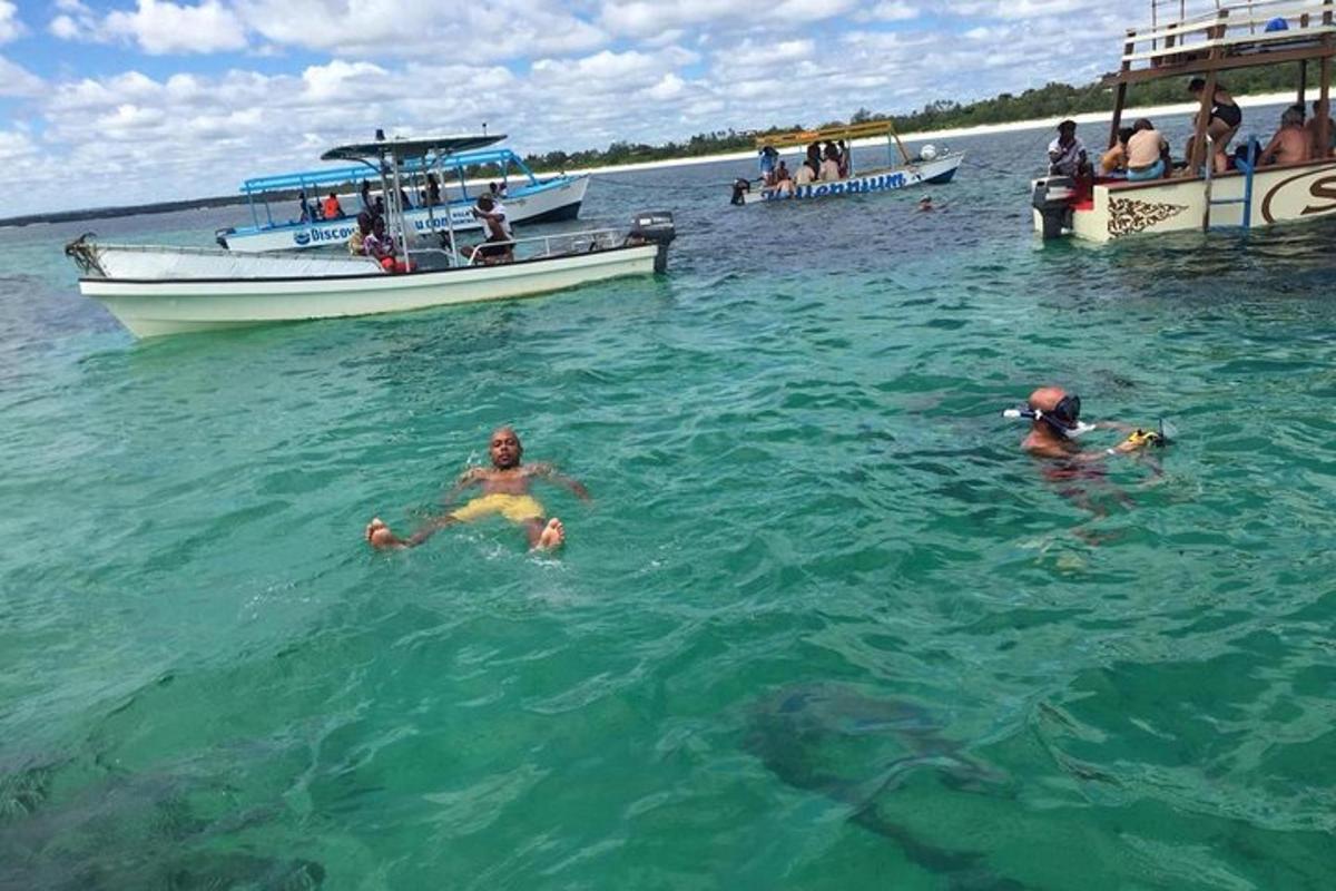 a group of people swimming in the water with boats