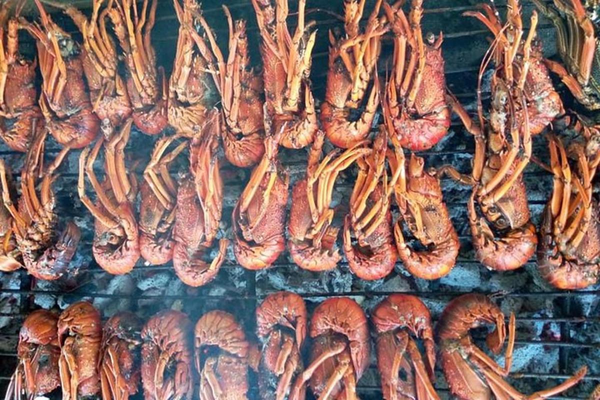 a bunch of bacon and sausages cooking on a grill
