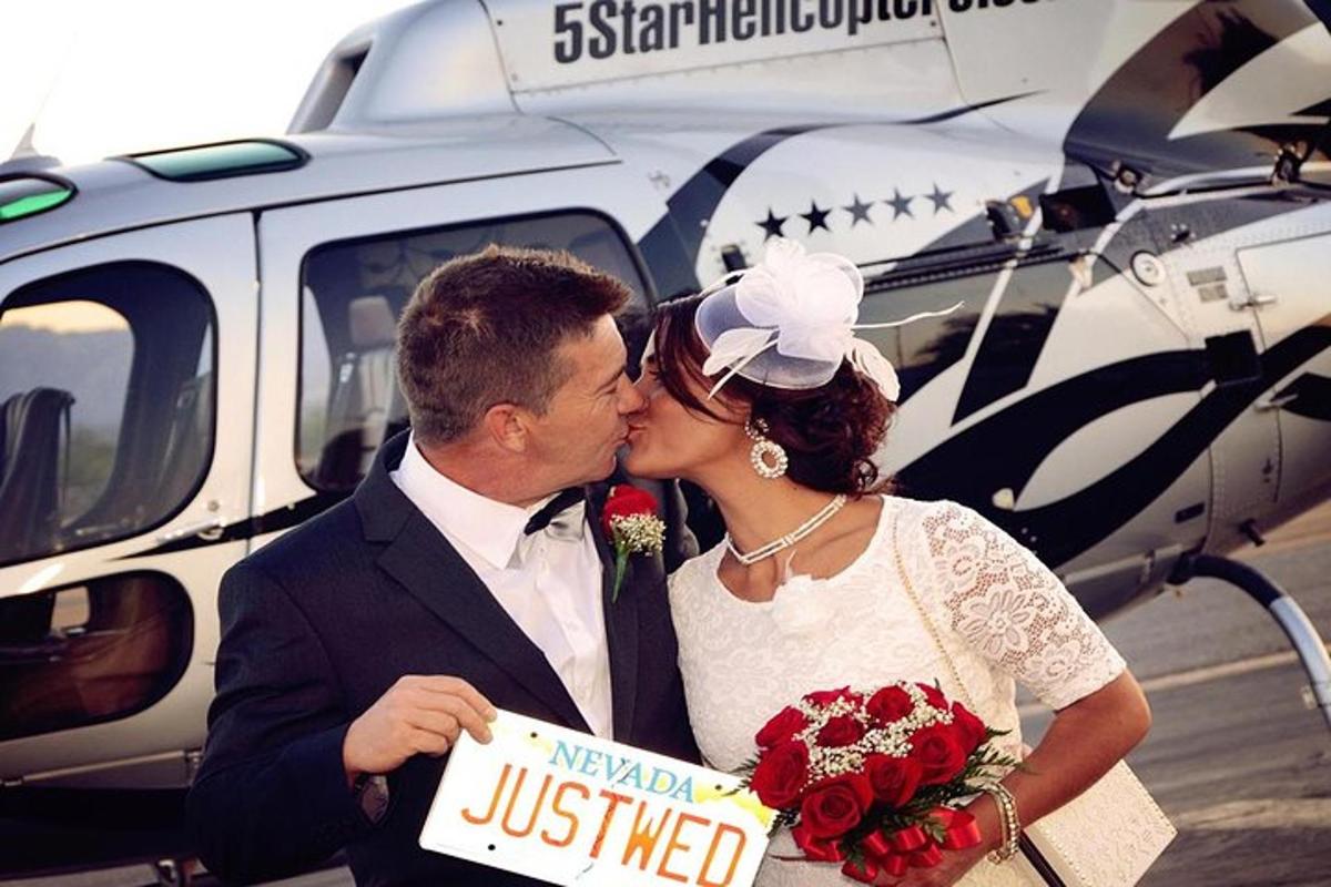 a bride and groom kissing in front of a plane