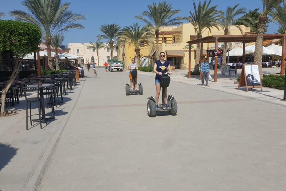 dva človeka se vozita s segwayi po ulici