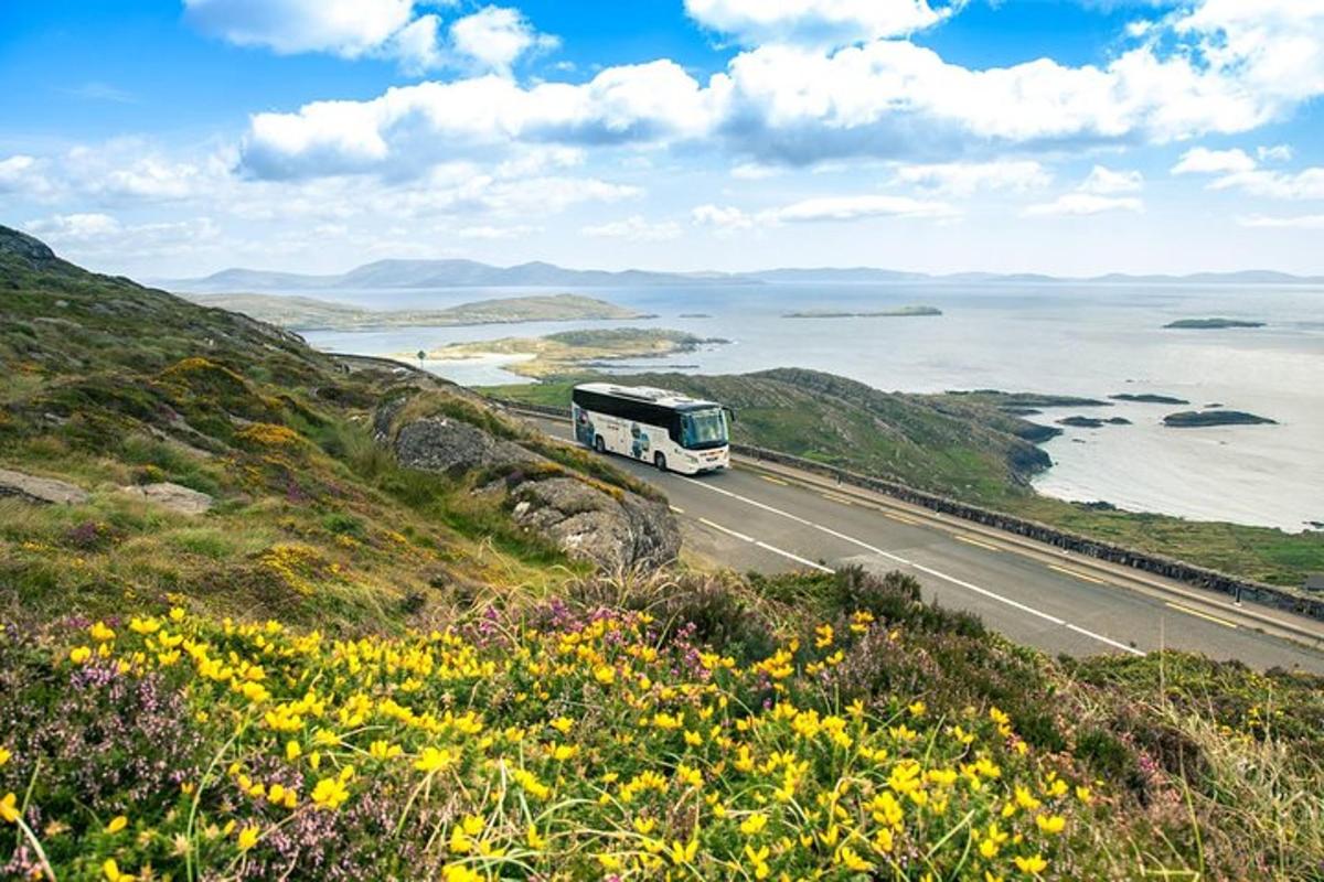 a bus driving down a road next to the ocean