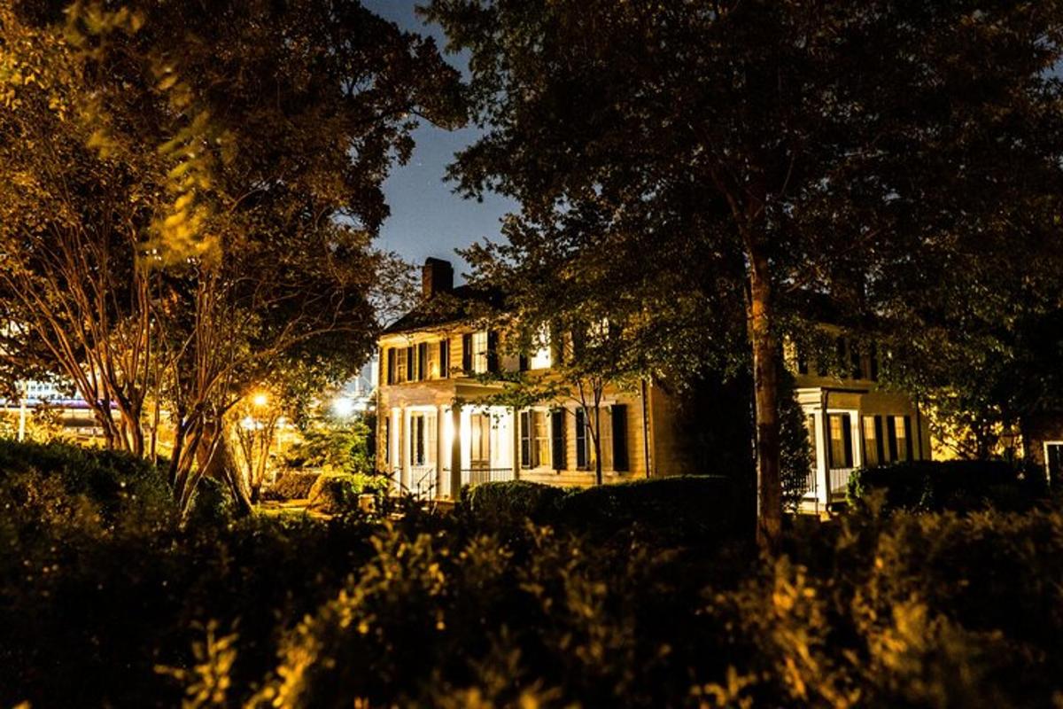 Una casa con luces encendidas en un patio por la noche.