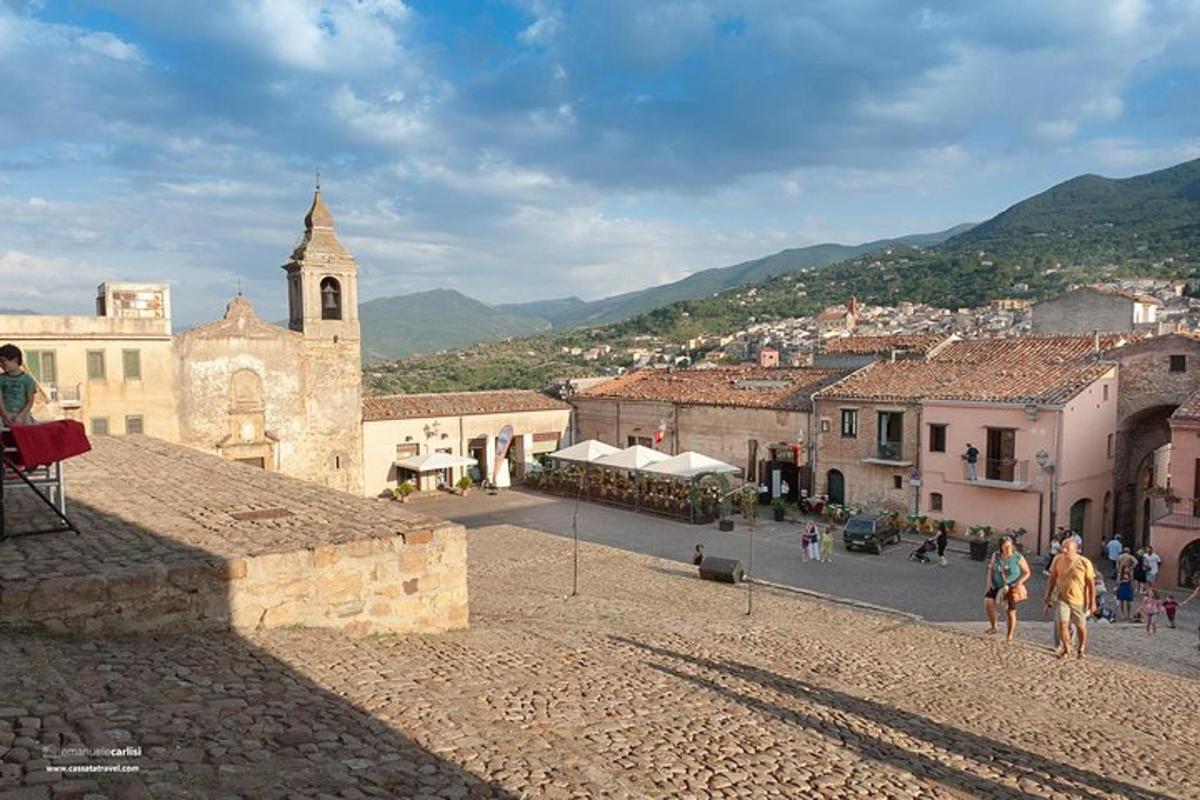 a group of people walking around a town with a church