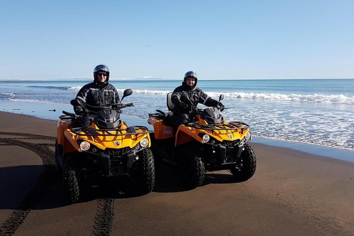 dos homes asseguts en quads a la platja
