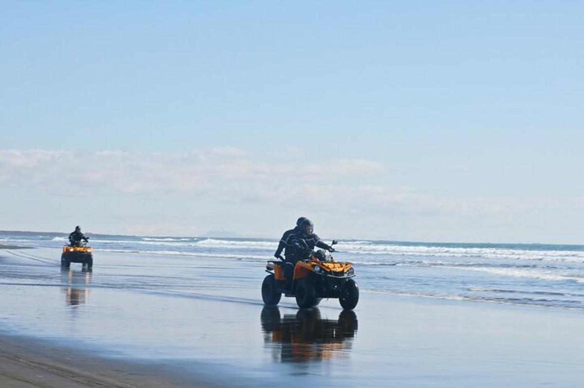 dues persones anant en quads a la platja