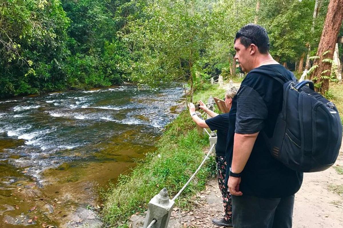 dvaja ľudia stojaci pri rieke s batohom