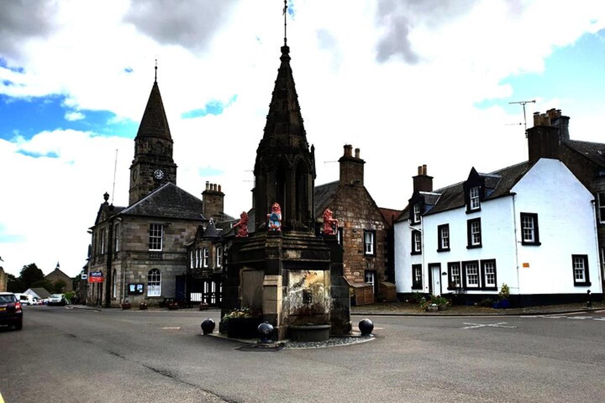 an old building with a fountain in the middle of a street