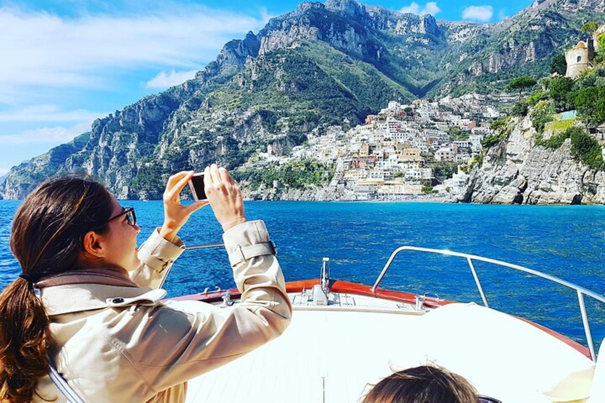Žena fotí pobřeží Amalfi na lodi