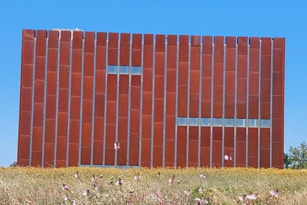 há rauð bygging með akri fyrir framan hana