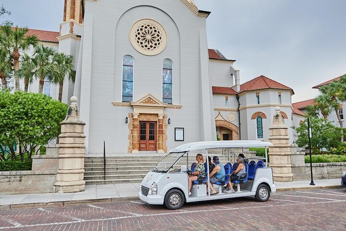 a group of people riding in a golf cart in front of a church