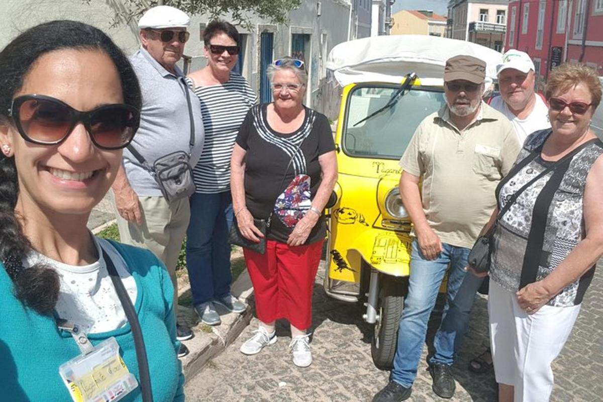 a group of people standing in front of a yellow car