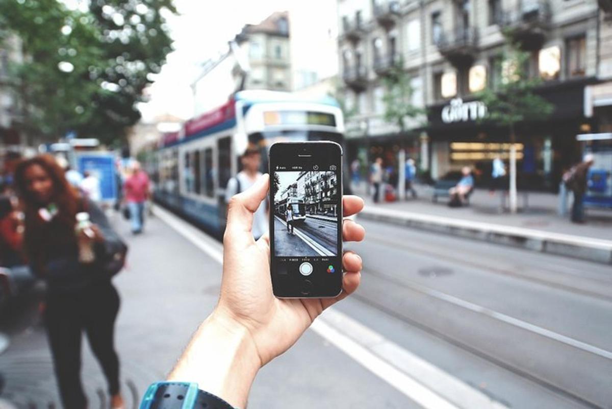 oseba, ki drži mobilni telefon, da bi fotografirala