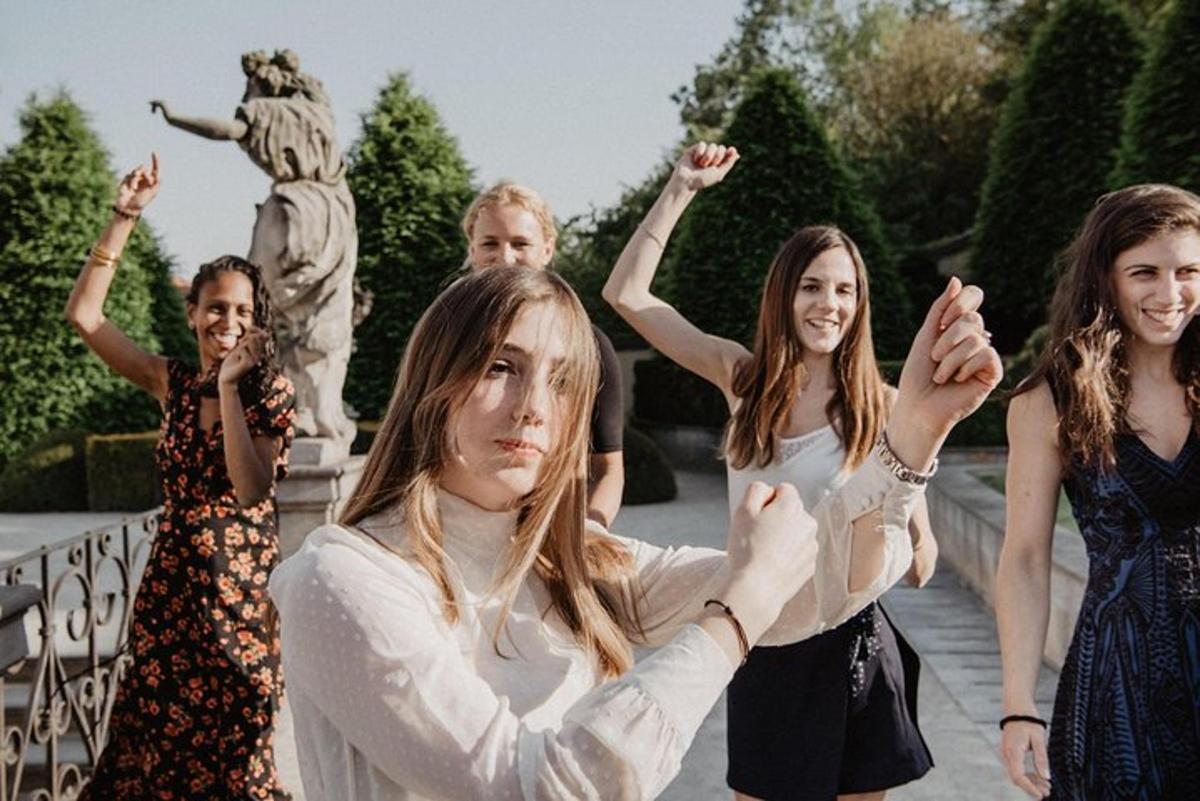 Un grupo de mujeres de pie frente a una estatua