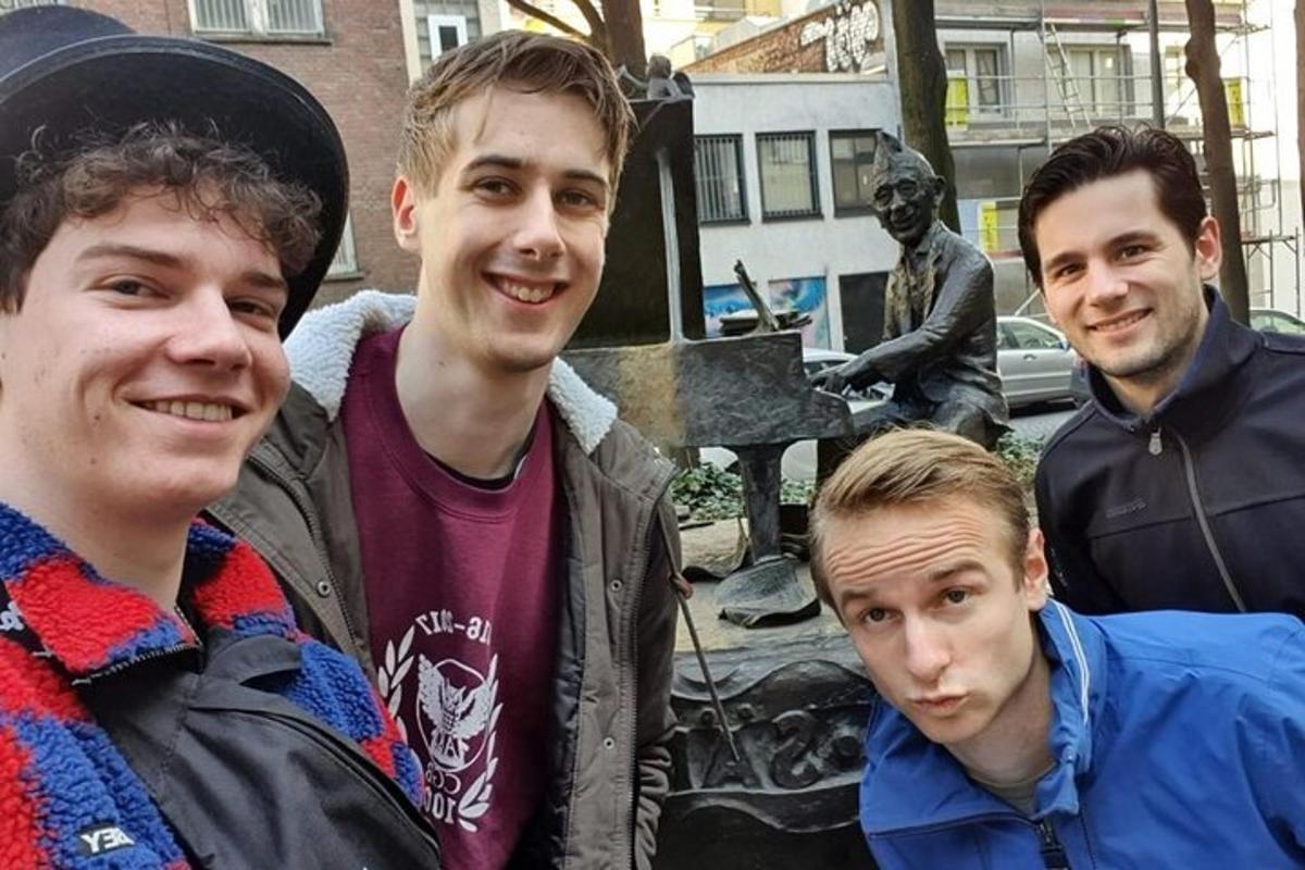 hópur ungra manna stendur fyrir framan styttu