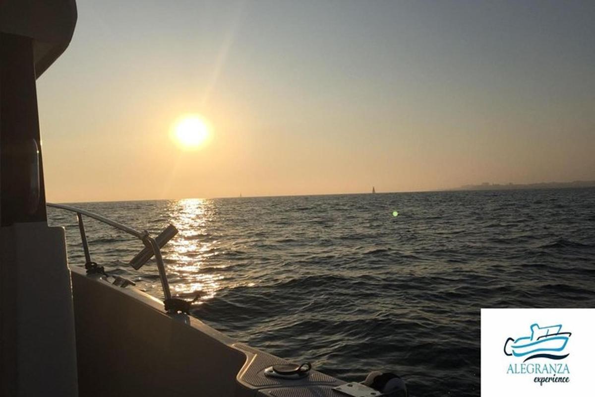 a boat in the ocean with the sun setting