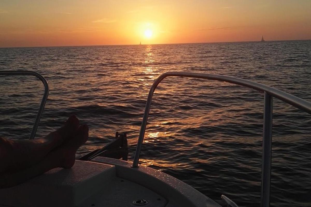 a person sitting on a boat watching the sunset