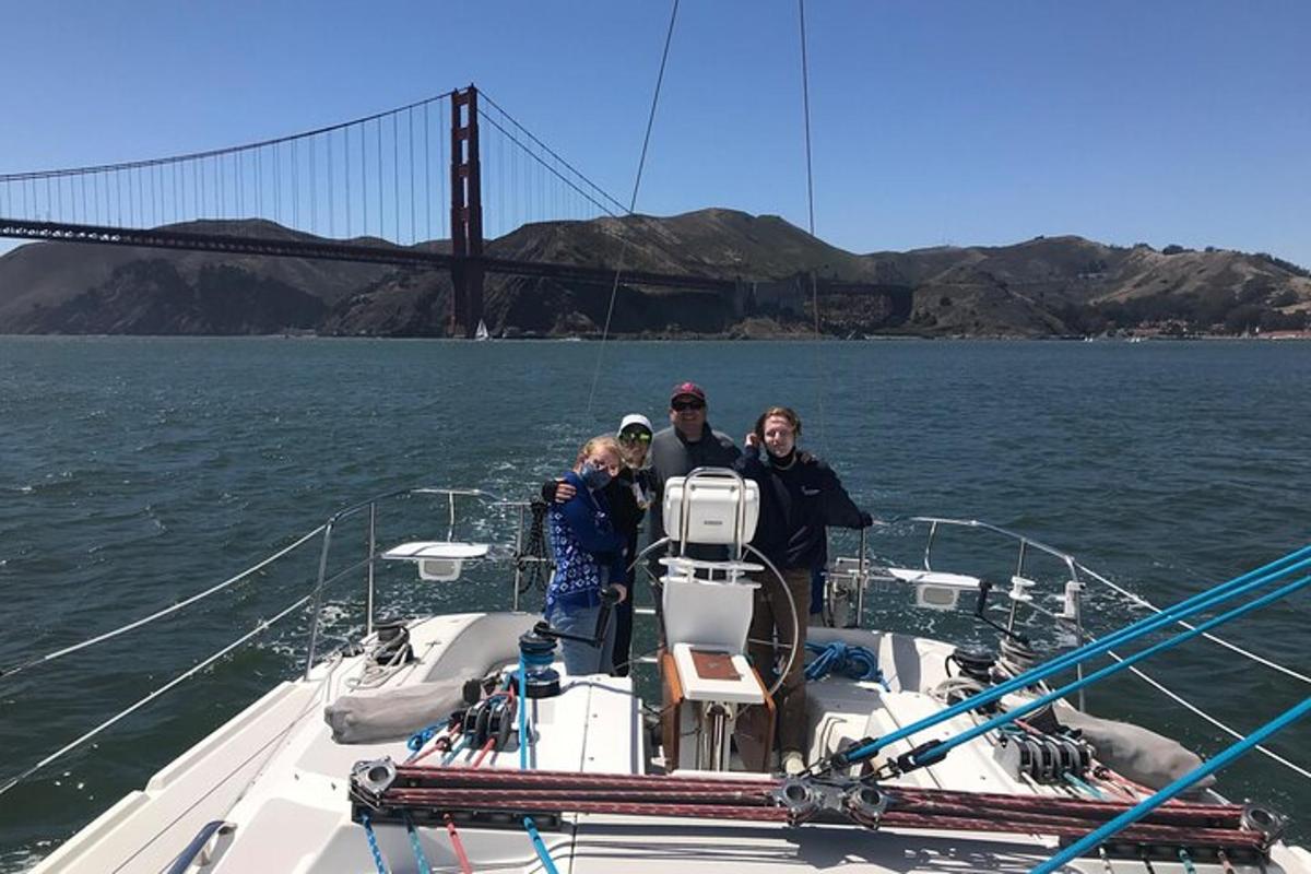 Tres personas en un barco con un puente al fondo