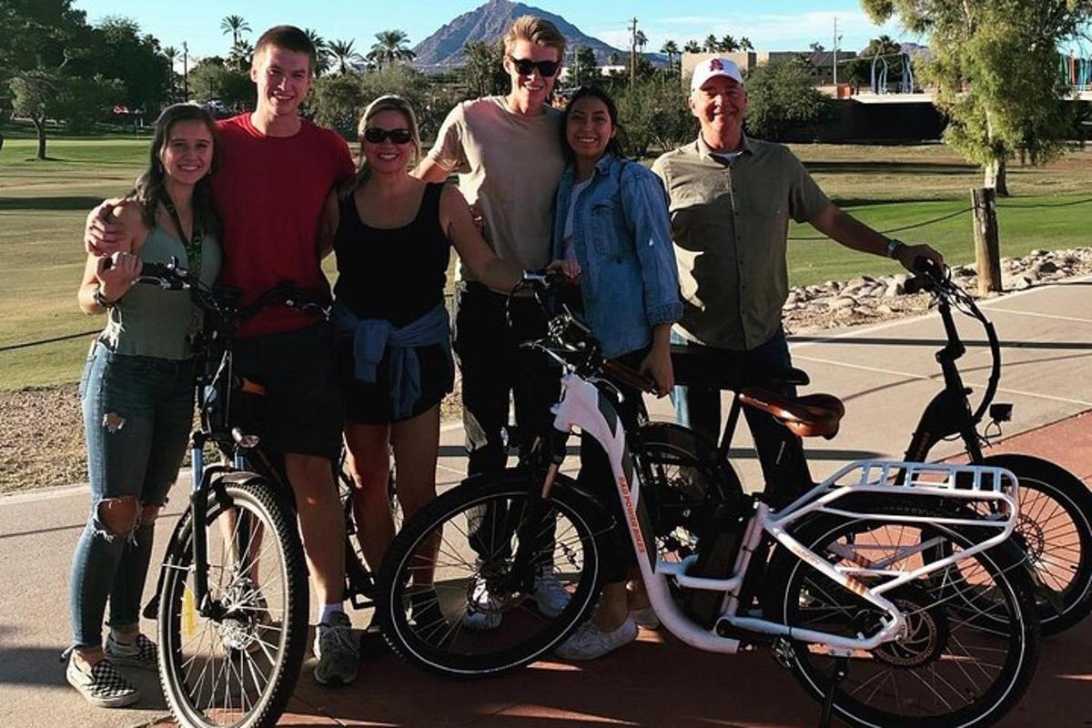 um grupo de pessoas posando para uma foto com suas bicicletas