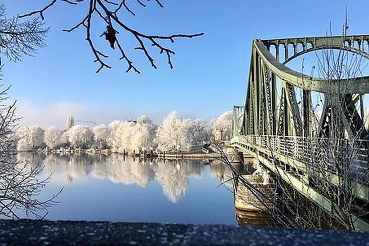 en bro over en vannmasse med snødekte trær
