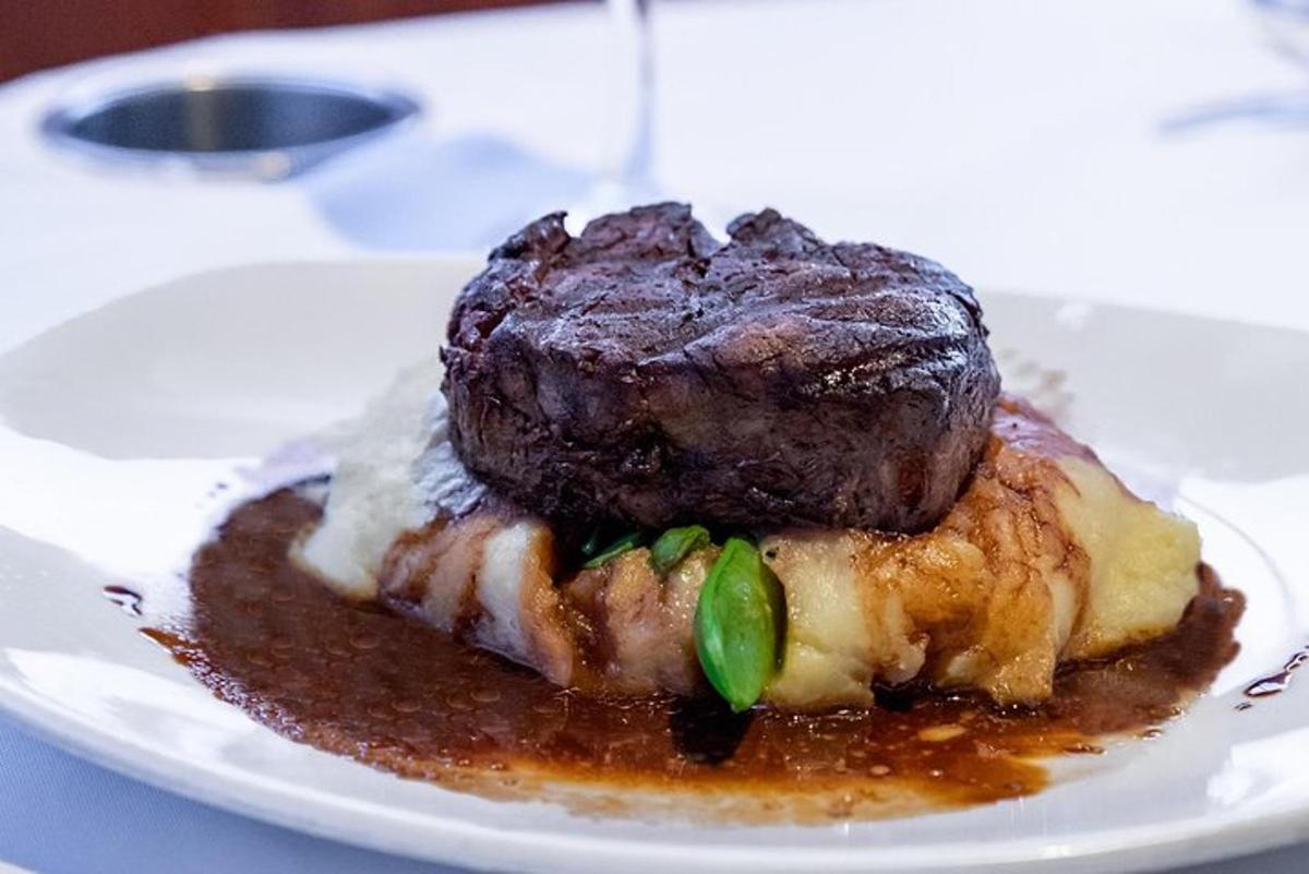 o bucată de carne pe o farfurie pe masă