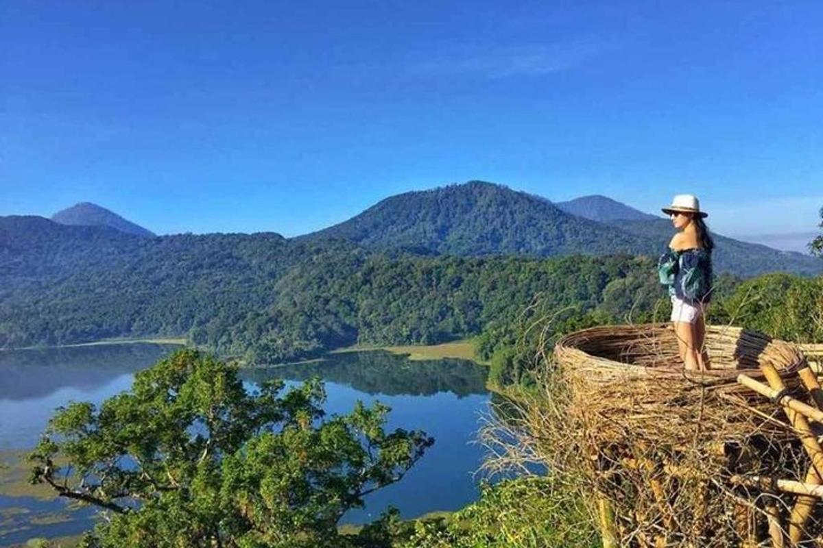 žena stojící na vrcholu hory s výhledem na jezero